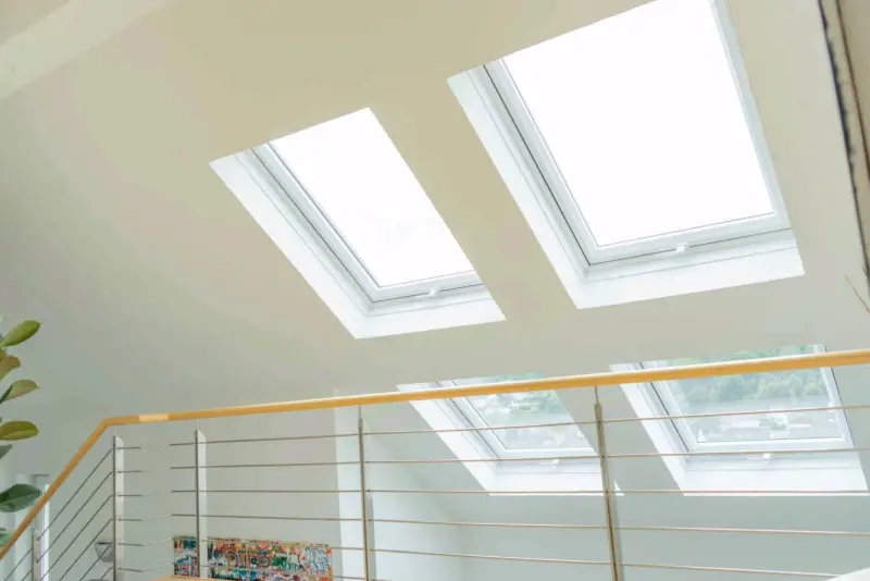 Helles Dachgeschoss mit zwei modernen weißen Dachfenstern, die viel Tageslicht hereinlassen