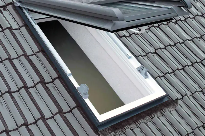 Modernes Dachfenster mit außenliegendem Rollladen in einem Ziegeldach